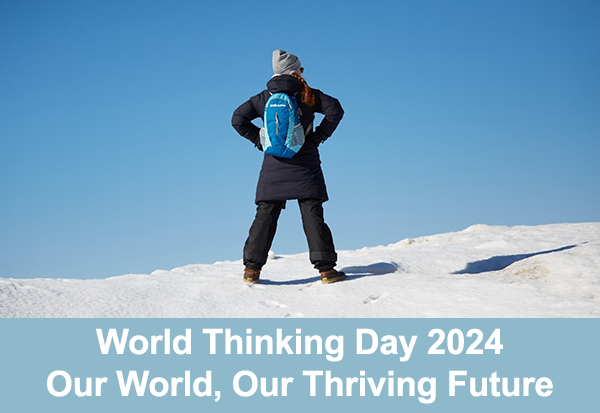 World Thinkiing Day 2024, Our World, Our Thriving Future text overlayed on image of the back of a girl standing on a snowy peak looking into the blue sky.